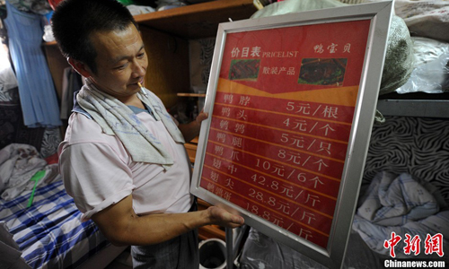 “Business is getting harder and rent has gone up to 1,000 yuan ($163.30) a month,” said Xu as he holds a sign displaying his limited menu. “My wife works in a restaurant and brings food back home sometimes. My son is now studying at a university. I hope he can find a good job in Beijing, but I know it’s very hard. ” Photo: Jin Shuo/chinanews.com 