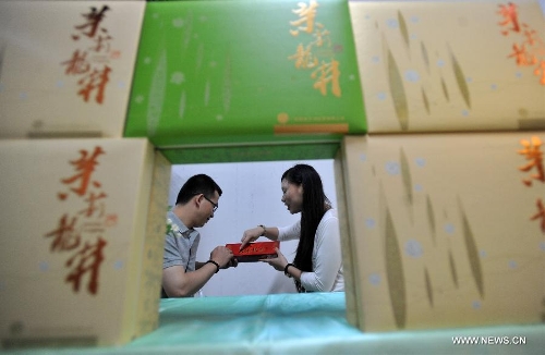 An exhibitor (R) introduces tea to a man at the 6th Guangxi Nanning Spring Tea Fair in Nanning, capital of south China's Guangxi Zhuang Autonomous Region, April 29, 2013. The five-day fair kicked off on Sunday. (Xinhua/Lu Boan) 