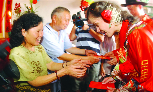 An American woman who married into a family in Chengdu, Sichuan Province, receives red envelop money from her in-laws during the wedding. Photo: CFP