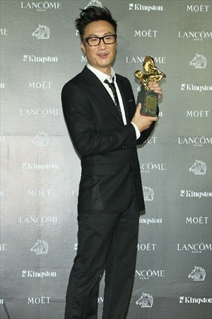 Hong Kong actor Ronald Cheng poses for photos of his trophy of the Best Supporting Actor award for the film 