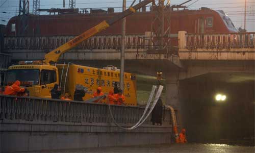 Worker drain the water at Lianhua Bridge in Beijing, capital of China, July 21, 2012. Photo: Xinhua
