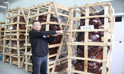 A drug trafficker identifies drugs seized by police in a warehouse in Guangdong Province. Police in Fujian Province announced Tuesday that they arrested five drug traffickers in March, confiscating 1.07 tons of ketamine hidden in hollow woodcarving.