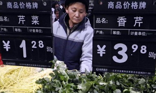 A consumer buys vegetable at a supermarket in Beijing, capital of China, December 9, 2012. China's consumer price index (CPI), a main gauge of inflation, grew 2 percent year on year in November, the National Bureau of Statistics announced Sunday. The inflation rate increased from a 33-month low of 1.7 percent in October as food prices increased. Photo: Xinhua