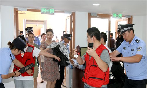 People pass through a security check point during a drill on Tuesday at a convention center in Karamay, Xinjiang Uyghur Autonomous Region. A tourism product expo will be held at the center on Friday. Photo: CFP