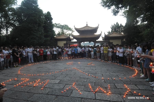 People light candles to mourn the death of Wang Jialin and Ye Mengyuan, two young girls killed in a crash landing of an Asiana Airlines Boeing 777 at San Francisco airport, in Jiangshan City, east China's Zhejiang Province, July 8, 2013. Local residents gathered at Xujiang Park in Jiangshan to show their grief to the 17-year-old Wang and 16-year-old Ye, who were students from Jiangshan High School. (Xinhua/Huang Shuifu)
