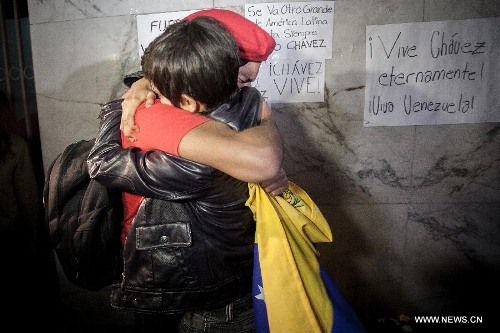 Residents hug with each other after the news of Venezuelan President Hugo Chavez's death was released, in Mexico City, capital of Mexico, on March 5, 2013. Venezuelan President Hugo Chavez died on March 5. (Xinhua/Pedro Mera)