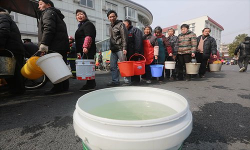 Residents in Songjiang district of Shanghai line up to get water supplies from a fire engine on Friday. Photo: CFP