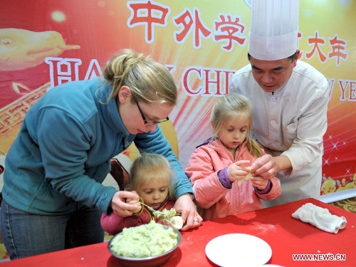 Children of an overseas student learn to make dumplings in an activity to celebrate the Chinese New Year at the Nanjing Agricultural University in Nanjing, capital of east China's Jiangsu Province, Feb. 4, 2013. More than 50 overseas students from over 20 countries and regions experienced Chinese traditional cultural activities with local students. (Xinhua)&nbsp; 