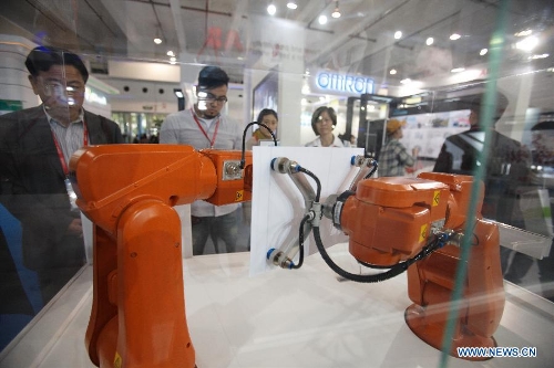 Visitors watch a smart robot drawing pictures during the China (Shanghai) International Technology Fair in Shanghai, east China, May 8, 2013. (Xinhua/Jin Xin) &nbsp;