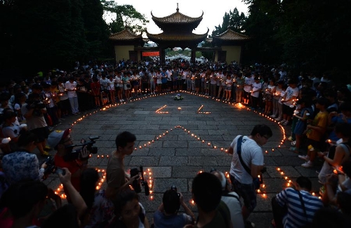 &nbsp;People light candles during a commemorating ceremony to mourn the death of Wang Jialin and Ye Mengyuan, two young girls killed in a crash landing of an Asiana Airlines Boeing 777 at San Francisco airport, in Jiangshan City, east China's Zhejiang Province, July 8, 2013. Local residents gathered at Xujiang Park in Jiangshan to show their grief to the 17-year-old Wang and 16-year-old Ye, who were students from Jiangshan High School. (Xinhua/Han Chuanhao)