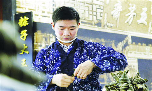 An employee at Wufangzhai, a well-known maker of traditional Chinese foods, wraps zongzi (glutinous rice dumplings) over the weekend. With demand for these seasonal treats set to peak during the upcoming Dragon Boat Festival, the company recently reported seeing its sales reach 200 million yuan ($32.2 million) during the first quarter after selling some 40 million zongzi. Photo: CFP 