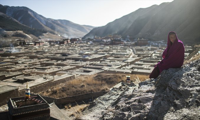 A monk sits on a hill overlooking the Labrang Monastery in Xiahe, Gansu Province on March 7. Photo: Li Hao/GT
