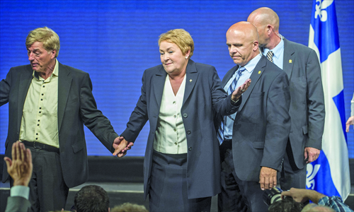 Pauline Marois, leader of the Parti Quebecois, is escorted by the security personnel after a gunman opened fire during her victory speech on Tuesday in Montreal. Photo: AFP 