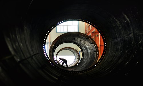A worker connects structural towers for wind turbines in the county of Zouping, East China's Shandong Province. Most wind power equipment manufacturing companies suffered losses last year, with over 40 percent of generation equipment going unused, according to a report released by the China Wind Power Center Monday. Photo: CFP