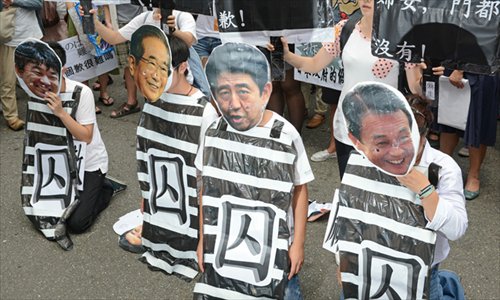 Protesters wear masks of Osaka Mayor Toru Hashimoto (left), former Tokyo governor Shintaro Ishihara (second from left), Japanese Prime Minister Shinzo Abe (second from right) and Deputy Prime Minister Taro Aso (right) during a rally to demand an apology from Japan over the comfort women issue, in front of the Japan Interchange Association in Taipei on Wednesday.  Historians say up to 200,000 young women, from the two Koreas, China, Indonesia and the Philippines, were forced to serve as sex slaves in Japanese army brothels during World War II. Photo: AFP