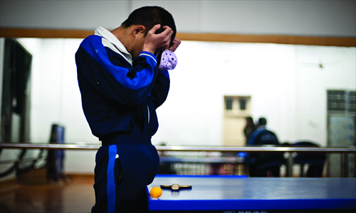 Liang Zhen, a vision-impaired boy, massages his eyes during his break.