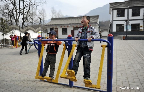  Photo taken on Feb. 5, 2013 shows children amusing themselves while playing gym equipment in Dongluo Village of Longnan City, northwest China's Gansu Province. In the year of 2008, a massive earthquake occurred in Gansu's neighbouring province Sichuan, and Longnan was also battered by the disaster. During the past five years, a total of 3,905 reconstruction projects have been carried out in the city, where over 240,000 households have their houses rebuilt, and hundreds of schools and hospitals have been set up as well. (Xinhua/Wang Yaodong) 