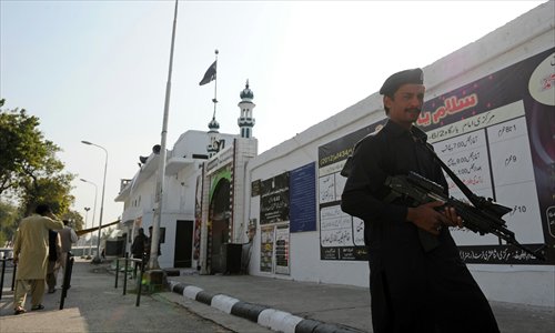 A Pakistani security serviceman stands guard near a Shiite Muslim mosque following overnight suicide bomb attacks on minority Shiite Muslims, in Islamabad on Thursday. Photo: AFP 