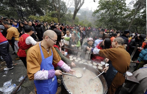  Citizens queue to get free porridge at Huayan Temple in Chongqing, southwest China, Jan. 19, 2013. The Huayan Temple distributed Laba porridge for free on Jan. 19, the eighth day of the 12th lunar month or the day of Laba Festival. The Laba Festival is regarded as a prelude to the Spring Festival, or Chinese Lunar New Year, the most important occasion of family reunion, which falls on Feb. 10 of this year. Drinking Laba porridge on the day of Laba is a traditional custom in China. (Xinhua/Zhou Ke) 