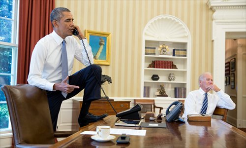 US President Barack Obama talks on the phone in the Oval Office with Speaker of the US House of Representatives John Boehneron on Saturday, as Vice President Joe Biden listens. Secretary of State John Kerry Sunday said the US has to act, following Obama's Saturday statement that he will ask Congress to authorize military action against Syria, lifting the threat of immediate strikes. Photo: AFP