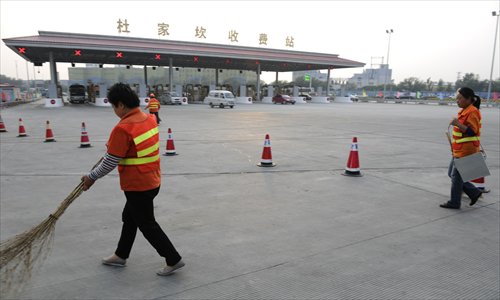 Cleaners work at the Dujiakan Toll Gate on the Beijing-Hong Kong-Macao Expressway Sunday. Traffic was flowing smoothly as of Sunday night. Photo: Li Hao/GT