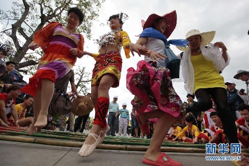 &nbsp;Photo taken on Feb. 11 shows visitors dancing with a Li ethnic girl in Sanya. According to the statistics issued on Feb. 15, by the national holiday tourism office for coordination meeting of inter-ministry and department, the totoal number of people touring 39 major resort and tourist cities of China reached 76,000,000 during this year's seven-day Spring Festival holiday, up 15 percent year on year. And the number of tourists visiting 33 popular scenic spots across China increased by 20 percent year on year. (Source: xinhuanet.com/photo)
