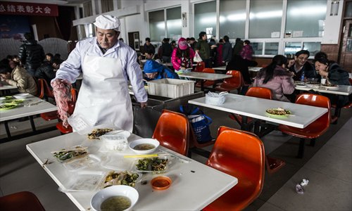 An employee collects the leftovers at a cafeteria in Shijingshan district Thursday. Photo: Li Hao/GT