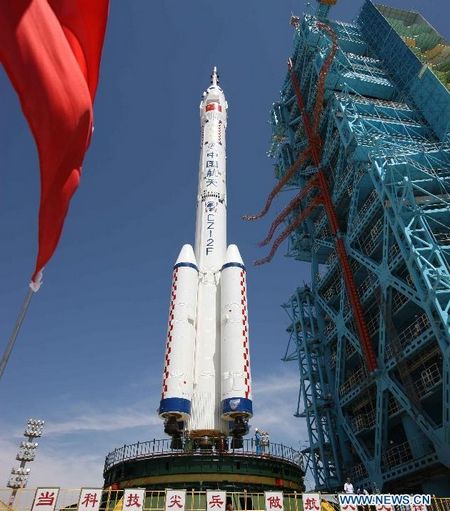 The Shenzhou-9 manned spacecraft, the Long March-2F rocket, and the escape tower are vertically transferred to the launch pad at the Jiuquan Satellite Launch Center in northwest China's Gansu Province, June 9, 2012. China will launch its Shenzhou-9 manned spacecraft sometime in mid-June to perform the country's first manned space docking mission with the orbiting Tiangong-1 space lab module, a spokesperson with the country's manned space program said Saturday.