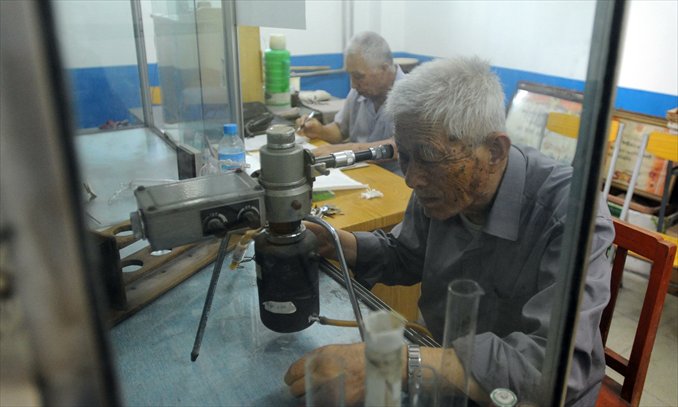 Retired teacher Chu Zijia checks the amount of radon in the underground water sample to determine seismic movement. Photo: CFP