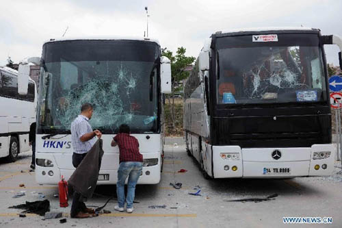 People gather outside a destroyed bus at the parking area of the Sinan Erdem Arena in Istanbul, Sunday, May 13, 2012. About 300 Panathinaikos' basketball fans attacked the buses with Olympiakos' supporters. Photo: Xinhua