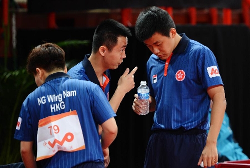 Tang Peng (R) and Ng Wing Nam (L) of Hong Kong of China talk to their coach Li Jing during the first round of mixed doubles against Pierre-Luc Theriault and Luo Anqi of Canada at Palais omnisport de Paris Bercy in Paris, France, on May 14, 2013. Tang and Ng won 4-1. (Xinhua/Tao Xiyi) 