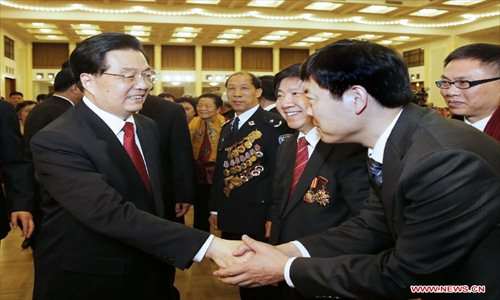 Chinese President Hu Jintao (left) shakes hands with a participant at a Spring Festival reception held by the Central Committee of the Communist Party of China and the State Council (Cabinet) at the Great Hall of the People in Beijing, capital of China, Feb. 8, 2013. Photo: Xinhua