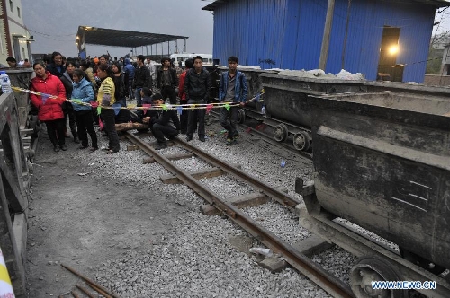 Relatives of the miners wait at the site of the accident in Shuicheng County, southwest China's Guizhou Province, March 13, 2013. Twenty-one miners were killed and four others were missing in a coal and gas outburst Tuesday evening at Machang Coal Mine which belongs to Gemudi Company of Guizhou Water & Mining Group. Eighty-three miners were working underground when the accident took place, and 58 of them managed to get to the ground safely. (Xinhua/Ou Dongqu) 