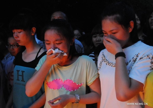 Students cry as mourning the death of Wang Jialin and Ye Mengyuan, two young girls killed in a crash landing of an Asiana Airlines Boeing 777 at San Francisco airport, in Jiangshan City, east China's Zhejiang Province, July 8, 2013. Local residents gathered at Xujiang Park in Jiangshan to show their grief to the 17-year-old Wang and 16-year-old Ye, who were students from Jiangshan High School. (Xinhua/Huang Shuifu)