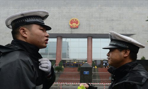 Two policemen stand guard outside the Chengdu City Intermediate People's Court on Monday, where Wang Lijun, received his verdict. Photo: AFP
