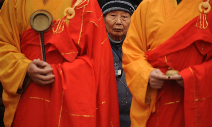 A Nanjing Massacre survivor is pictured Thursday between Chinese Buddhist monks at a ceremony for the victims killed by Japanese soldiers 75 years ago in Nanjing, Jiangsu Province.  The two countries' ties are at a new low following Japan's recent attempt to 