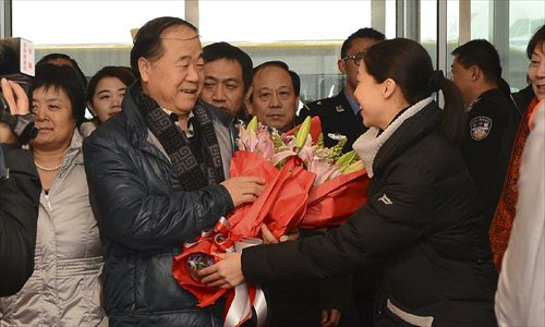 Winner of the 2012 Nobel Prize for Literature, Chinese writer Mo Yan (L, front), is welcomed at the Beijing Capital International Airport in Beijing, capital of China, Dec. 14, 2012. Mo Yan returned to Beijing on Friday after receiving Nobel Prize in Literature at the 2012 Nobel Prize ceremony in Stockholm, Sweden. Photo: Xinhua