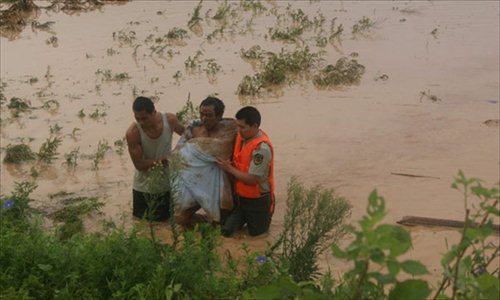 Rescuers evacuate a resident after the dam of the Shenjiakeng Reservoir breached in Daishan County, east China's Zhejiang Province, Aug. 10, 2012. The death toll from a flood that occurred Friday morning following the breach of the Shenjiakeng Reservoir has risen to ten, local rescuers said. The flood also injured 27 people. Zhejiang has been lashed by downpours over the last few days with the arrival of typhoon Haikui, which landed in the province early Wednesday morning. Photo: Xinhua