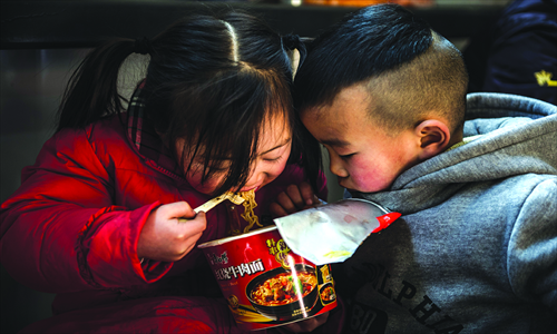 1. Children share a humble meal of instant noodles at the Beijing West Railway Station. 