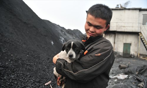 The youngest worker, surnamed Li, tends to a dog he rescued. Photo: CFP