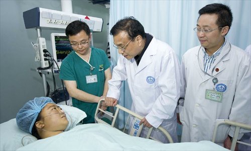 Chinese Premier Li Keqiang (2nd L) visits a patient seriously injured in an earthquake, at Huaxi Hospital in Chengdu, capital of Southwest China's Sichuan Province, April 21, 2013. A 7.0-magnitude earthquake jolted Lushan county of Sichuan Province on April 20 morning. Photo: Xinhua 