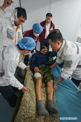 Health workers of Chongqing emergency medical service team prepare to give treatment to an injured person transported from the quake-hit Baoxing County in southwest China's Sichuan Province, April 21, 2013. al authorities. (Xinhua/Li Xin) 