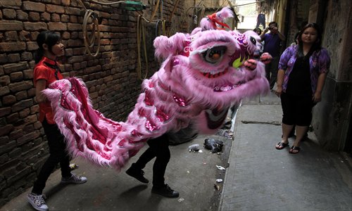 Chinese watch a dragon dance in an alley during celebrations marking the Chinese New Year in Calcutta, India in February 2012. Photo: IC