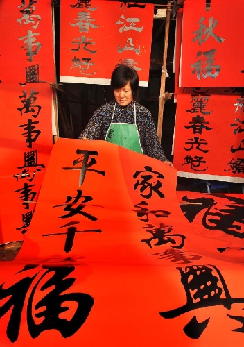 A villager puts spring couplets for sale in order in a shop in Beixiezhuang Village of Yuezhuang Town in Xinyuan County, east China's Shandong Province, Jan. 14, 2013. As traditional Chinese Spring Festival is coming, villagers here are busy with making spring couplets, a Spring Festival's decoration pasting on doors that expresses happy and hopeful thoughts for the coming year. (Xinhua/Zhao Dongshan) 
