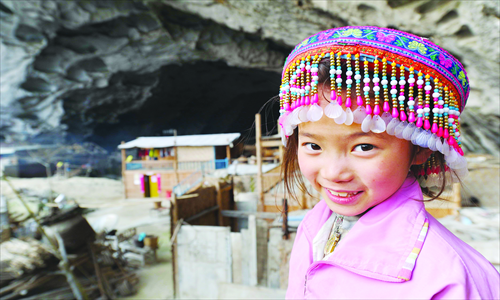 Uma jovem de uma tradicional Miao cocar está na frente da caverna Foto: PCP