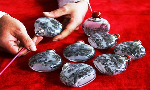 A tiny brush is used to paint on the inside surface of these palm-sized vessels. Photo: CFP