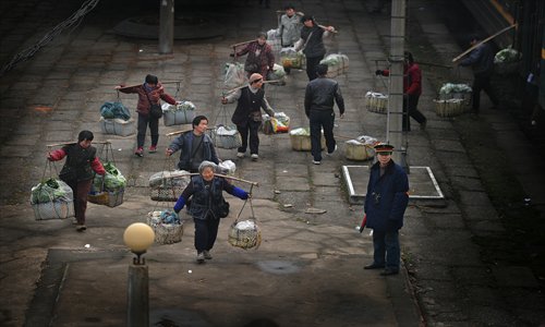 Farmers rush to catch the train to downtown Wuchang, a district of Wuhan in Hubei Province, with loads of vegetables. Photo: CFP