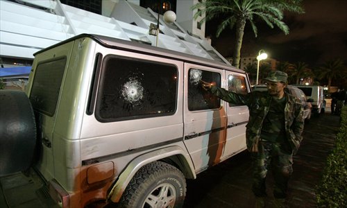 Libyan security inspect the bullet-proof vehicle in which Italy's consul to Benghazi was riding in, after it was shot at, in eastern Libya, on Saturday. The vehicle, in which the consul Guido De Sanctis was traveling in, was shot at when it stopped at a crossroads, but no one was injured, the Italian news agency ANSA reported. Photo: AFP 