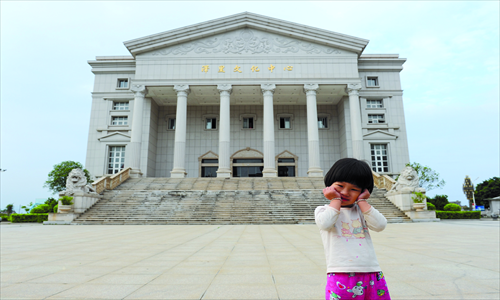 A girl plays outside a cultural hall in the town of Tantou, built with contributions from people who have moved overseas. Photo: CFP