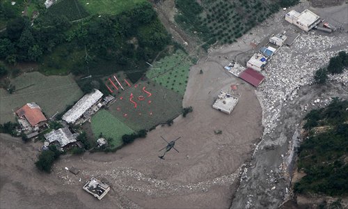 The photo taken from a military helicopter on Saturday shows a giant SOS placed on the ground in the Aba Tibetan Autonomous Prefecture in Sichuan Province. Three helicopters were dispatched to transport daily necessities and medication to the region, which has been swept by rainstorms and rainstorm-triggered landslides. Photo: IC